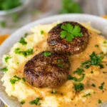 Frikadellen mit Kartoffelpüree und Pilzrahmsoße auf einem Teller serviert